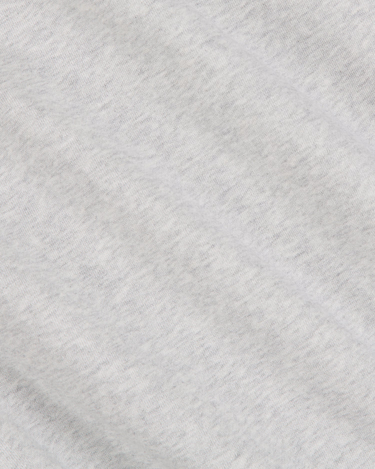 A close-up of the light gray heathered fabric showcases its soft, lightly textured surface and gentle diagonal folds—an ideal choice for the Notre Dame X Guinness Heavyweight Pullover Hoodie by Ebbets Field, blending comfort with timeless Irish-inspired style.