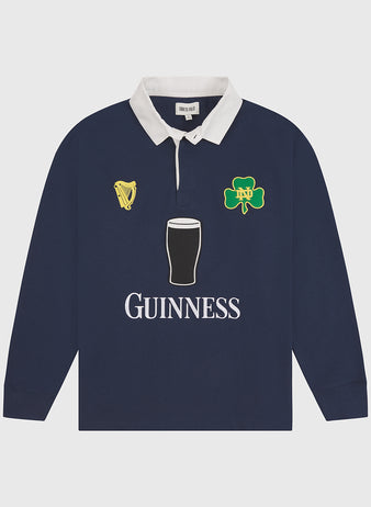 Ebbets Field’s Notre Dame X Guinness Rugby Shirt features a classic navy design with a white collar, detailed with harp, shamrock, and pint of stout emblems on the chest, plus “Guinness” printed below—an iconic piece that proudly celebrates Irish heritage.