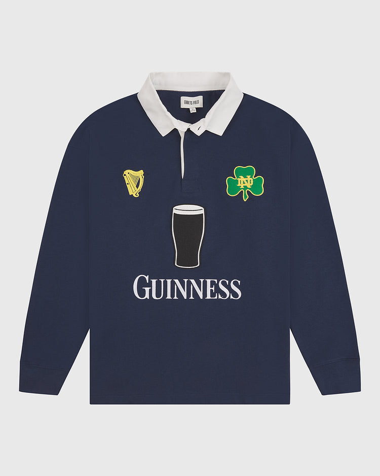 Ebbets Field’s Notre Dame X Guinness Rugby Shirt features a classic navy design with a white collar, detailed with harp, shamrock, and pint of stout emblems on the chest, plus “Guinness” printed below—an iconic piece that proudly celebrates Irish heritage.