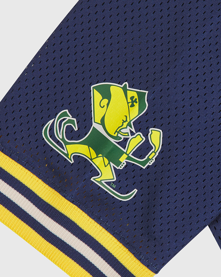 The Notre Dame Football Jersey by Ebbets Field features navy mesh fabric with a yellow and green leprechaun mascot logo—sporting a hat and raised fists—on the sleeve, accented with yellow, white, and navy striped trim.