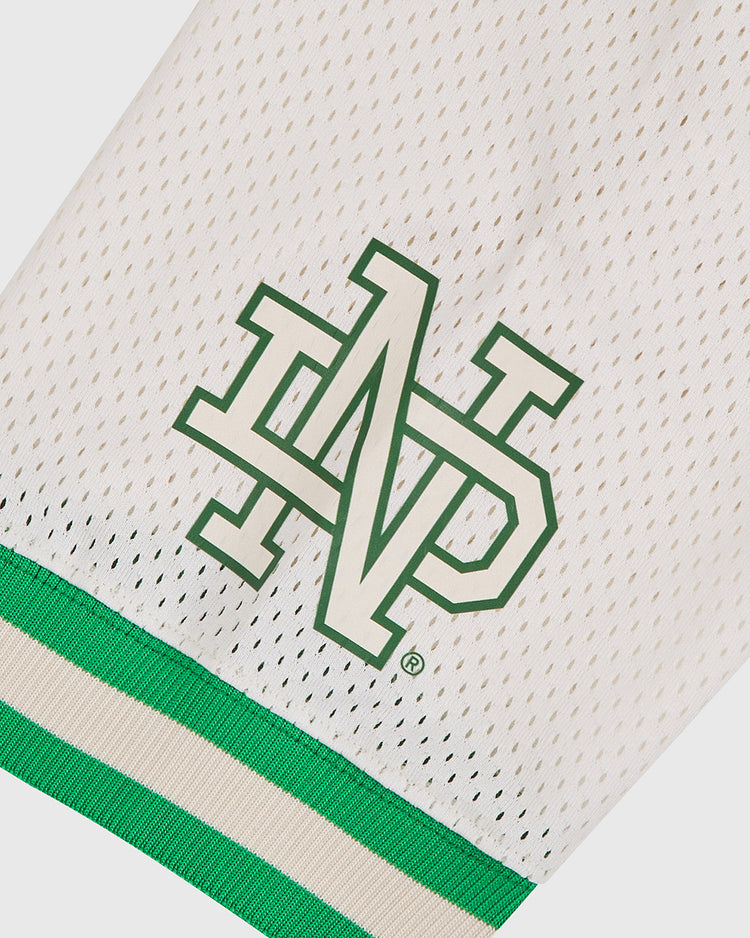 Introducing the Notre Dame X Guinness Mesh Football Jersey by Ebbets Field: crafted from white mesh fabric with green and cream trim, this jersey showcases an interlocking N and D logo outlined in green, channeling the timeless style of vintage football jerseys—an authentic tribute to Irish heritage football traditions.
