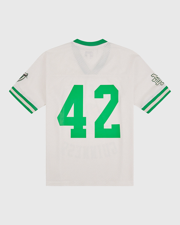 The Notre Dame X Guinness Mesh Football Jersey by Ebbets Field is a white vintage jersey with green-striped sleeves and bold green number 42 on the back, blending classic athletic style with a celebration of Irish heritage.