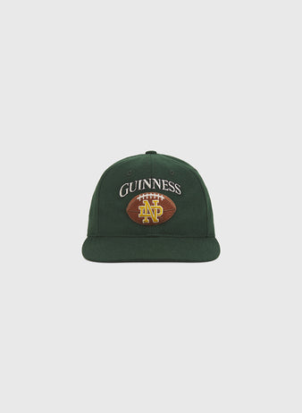 Celebrate Notre Dame pride with the Ebbets Field Notre Dame X Guinness Wool Ballcap—a green wool cap featuring “GUINNESS” embroidered above a football design with bold yellow ND letters on the front.