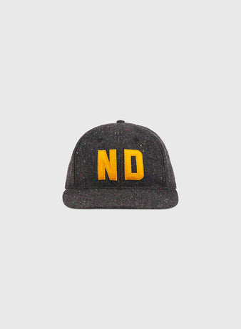 A Notre Dame X Magee Irish Donegal Wool Ballcap by Ebbets Field in dark gray, featuring yellow embroidered ND lettering on the front, displayed against a plain light background.