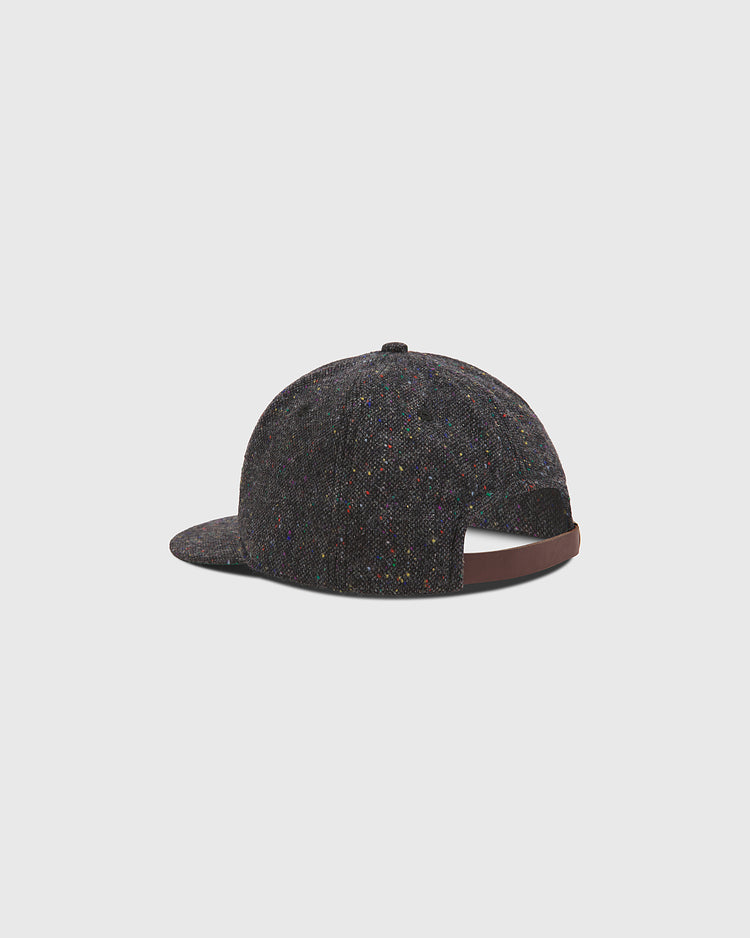 A Notre Dame X Magee Irish Donegal Wool Ballcap by Ebbets Field, featuring dark speckled Donegal wool and a curved brim, is shown from the back with a brown adjustable strap, set against a plain light background.