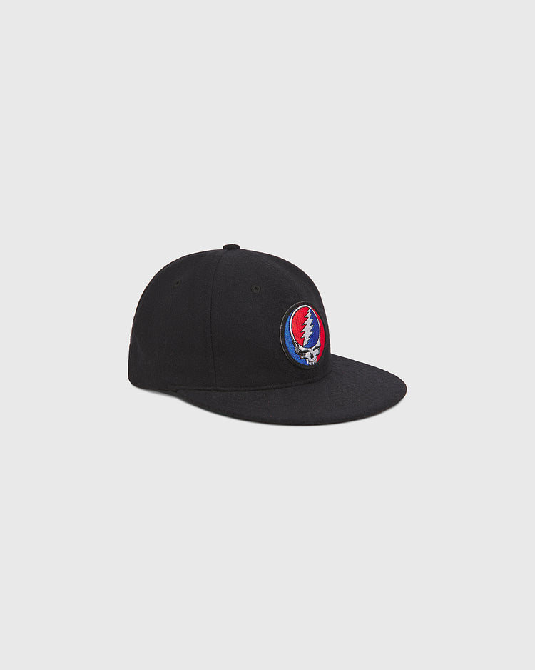 The Ebbets Field Grateful Dead Stealie Wool Ballcap features a black wool construction and a circular patch with the iconic red, white, and blue Stealie lightning skull logo on the front, displayed against a clean light gray backdrop—an ideal accessory for any Grateful Dead fan.