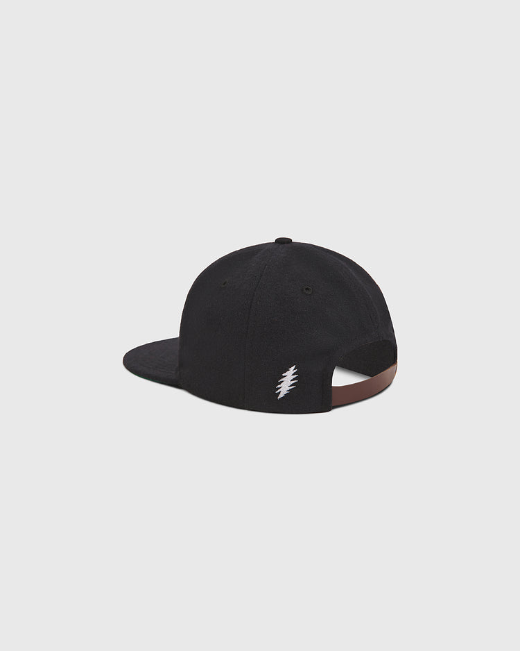 The Ebbets Field Grateful Dead Stealie Wool Ballcap is pictured from the back, displaying a small white lightning bolt embroidered near its adjustable brown strap. The background is a plain light gray.