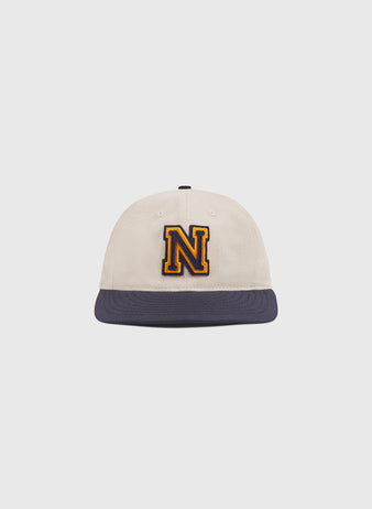The Ebbets Field Navy 1958 Logo Cotton Twill Ballcap features a beige crown with a navy blue brim and a large, yellow-outlined letter N embroidered on the front, displayed centered against a plain white background.