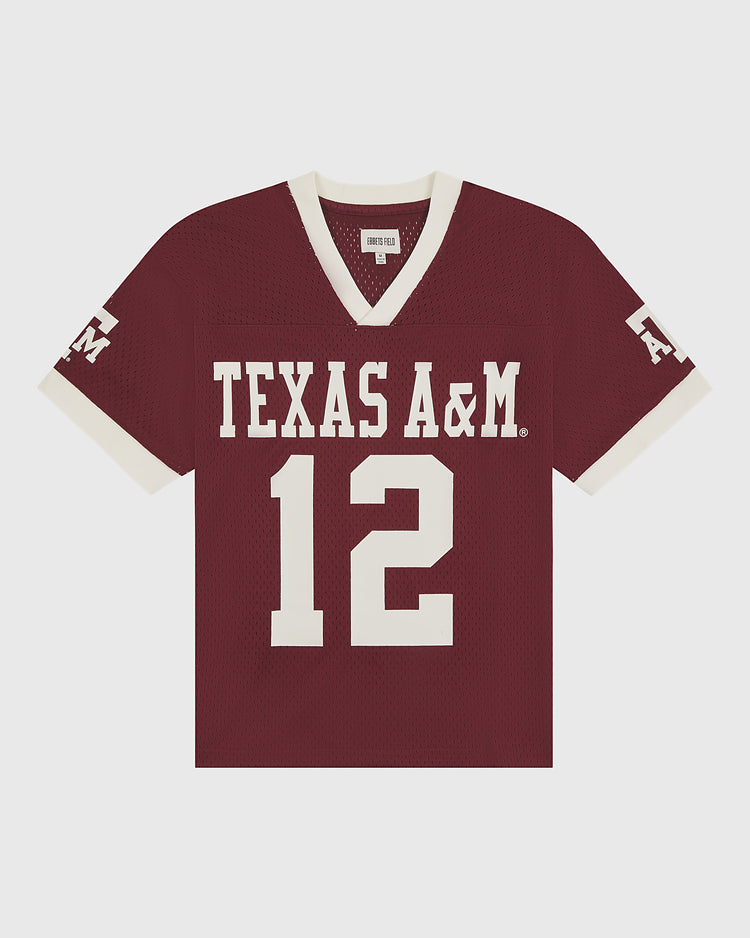 Crafted by Ebbets Field, the Texas A&M Mesh Football Jersey showcases a vintage maroon mesh design with sharp white trim, featuring “TEXAS A&M” and the number 12 prominently on the front, while “A&M” appears on the left sleeve for timeless game day style.