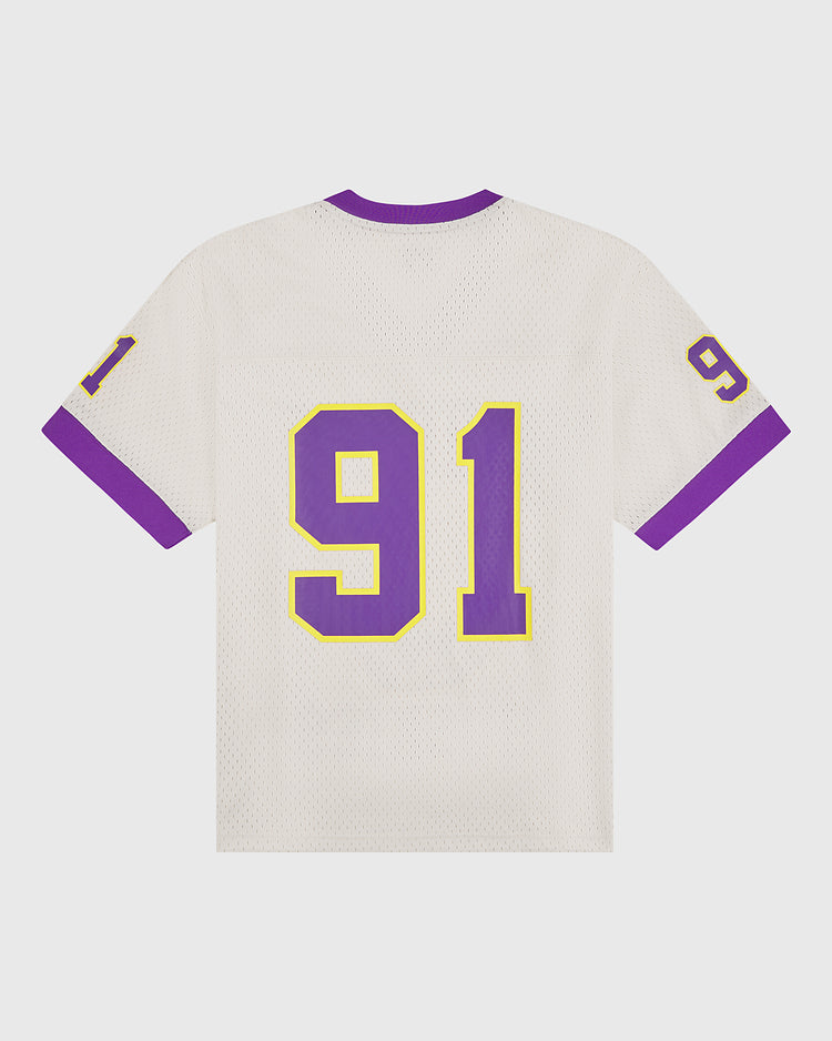 The Ebbets Field University of Washington Mesh Football Jersey features a white mesh design with a purple collar and sleeve trim, capturing the spirit of the Huskies. The number 91, outlined in yellow, stands out prominently on the back and appears smaller on each sleeve—a nostalgic tribute to Rose Bowl heritage.