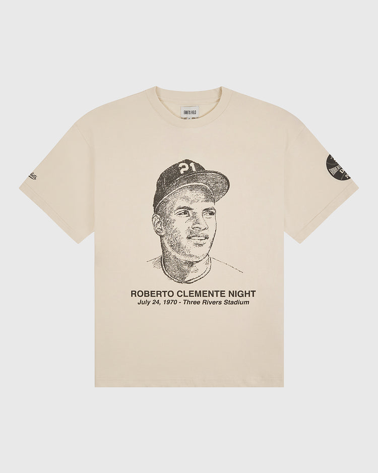 Celebrate an iconic moment in baseball history with The Clemente Museum x Ebbets Field Short Sleeve Graphic T-Shirt by Ebbets Field. This beige tee features a sketched portrait of a baseball player and the text “Roberto Clemente Night, July 24, 1970 - Three Rivers Stadium” below, along with a commemorative patch on the left sleeve. A must-have graphic tee for any Roberto Clemente or Pittsburgh Pirates fan.