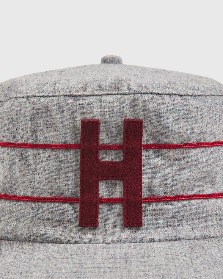 The Ebbets Field Harvard University 1899 Pillbox Wool Ballcap features gray wool fabric with two parallel red stripes and a large, dark red “H” embroidered on the front.