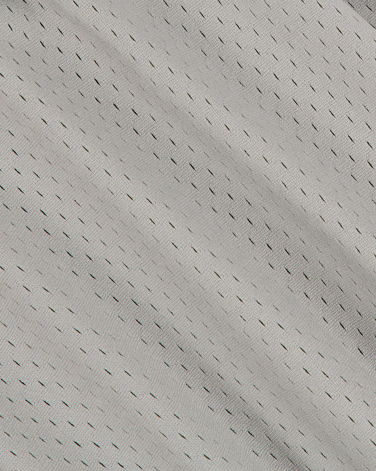 Close-up of the Los Angeles (PCL) 1942 Mesh Button Up Road Jersey by Ebbets Field, showing light gray athletic mesh fabric with small, evenly spaced black ventilation holes forming a subtle diagonal pattern across the surface.