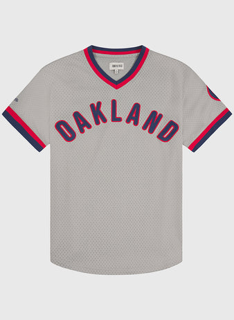 Ebbets Field Oakland Oaks 1948 Mesh V-Neck Road Jersey featuring “OAKLAND” in bold red and blue letters across the front, with blue and red trim along the collar and sleeve edges.