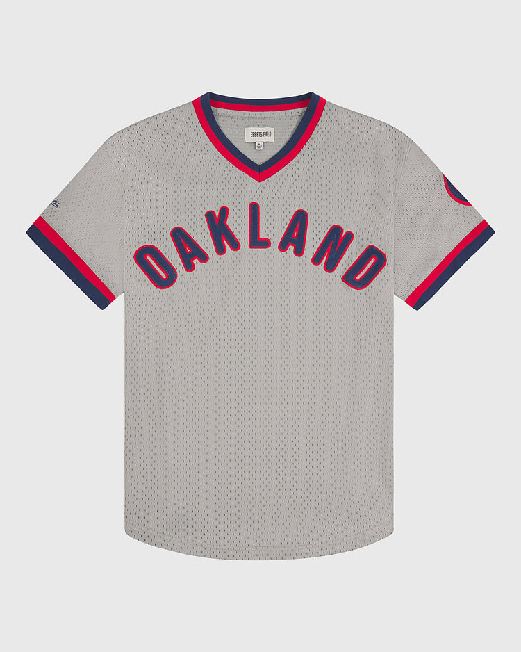 Ebbets Field Oakland Oaks 1948 Mesh V-Neck Road Jersey featuring “OAKLAND” in bold red and blue letters across the front, with blue and red trim along the collar and sleeve edges.