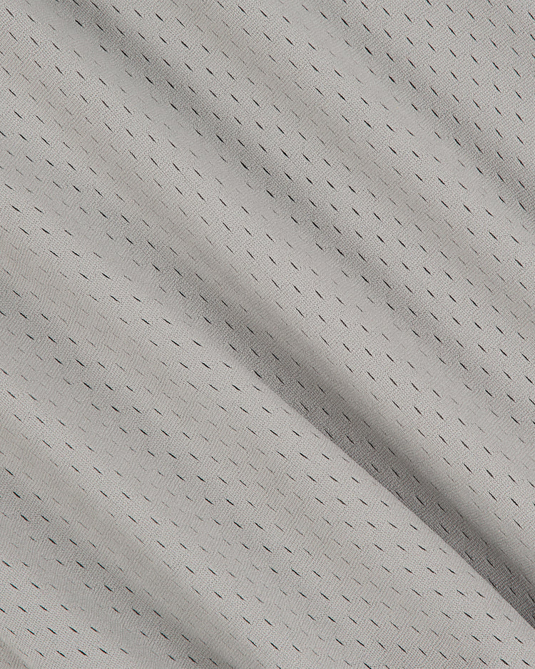 Close-up of the Oakland Oaks 1948 Mesh V-Neck Road Jersey by Ebbets Field, featuring light gray, textured mesh fabric with small, evenly spaced black dashed lines running diagonally across the surface. The material appears soft and slightly wrinkled.