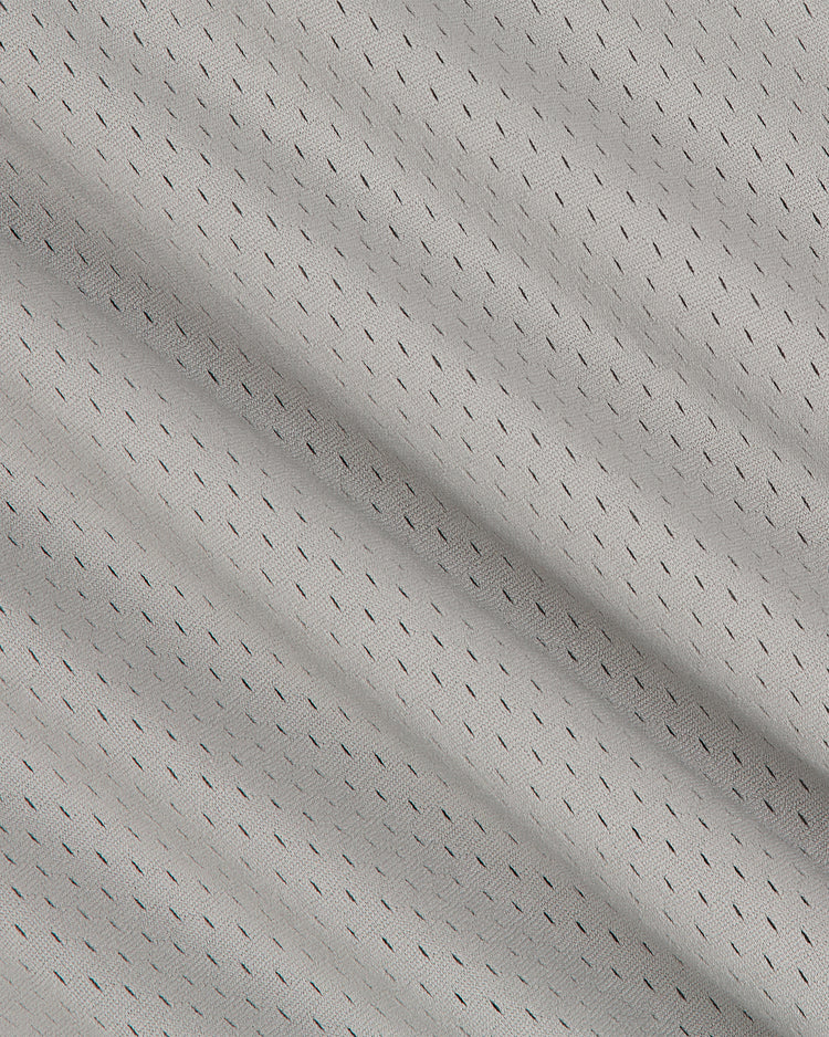 Close-up of the Seattle Rainiers 1951 Mesh V-Neck Road Jersey by Ebbets Field, featuring light gray, breathable athletic mesh with small, evenly spaced perforations and subtle folds. The texture and pattern showcase its moisture-wicking material, ideal for sportswear or activewear.