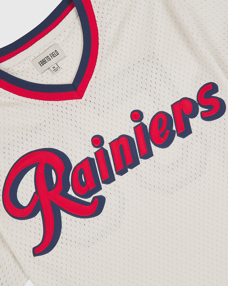 This is the Seattle Rainiers 1955 Mesh V-Neck Home Jersey by Ebbets Field, featuring white mesh fabric with blue and red trim on the collar and sleeves. “Rainiers” is displayed across the chest in bold blue and red script lettering.