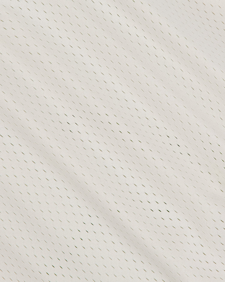 Close-up of the Seattle Rainiers 1955 Mesh V-Neck Home Jersey by Ebbets Field, showcasing its white mesh fabric with small, evenly spaced holes and a slightly diagonal seam across the material. The texture appears breathable and lightweight.