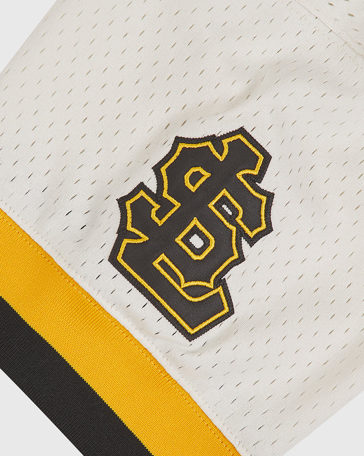 A close-up of a white mesh Salt Lake City Bees 1959 Mesh V-Neck Home Jersey sleeve by Ebbets Field, featuring a black and gold interlocking STL logo and a yellow and black stripe near the edge.