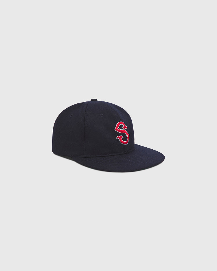 The Ebbets Field Seattle Rainiers 1950 Authentic Wool Ballcap is a vintage black wool baseball hat, featuring a red and white embroidered “S” on the front, displayed against a plain light gray background—a true homage to the classic style of the 1950 Seattle Rainiers.