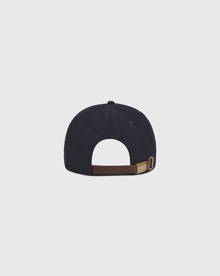 A navy blue Seattle Rainiers 1950 Authentic Wool Ballcap by Ebbets Field, shown from the back with a brown adjustable strap and brass buckle, displayed against a plain light gray background. Inspired by the classic vintage baseball hat, this wool cap pays homage to the iconic 1950 Seattle Rainiers.