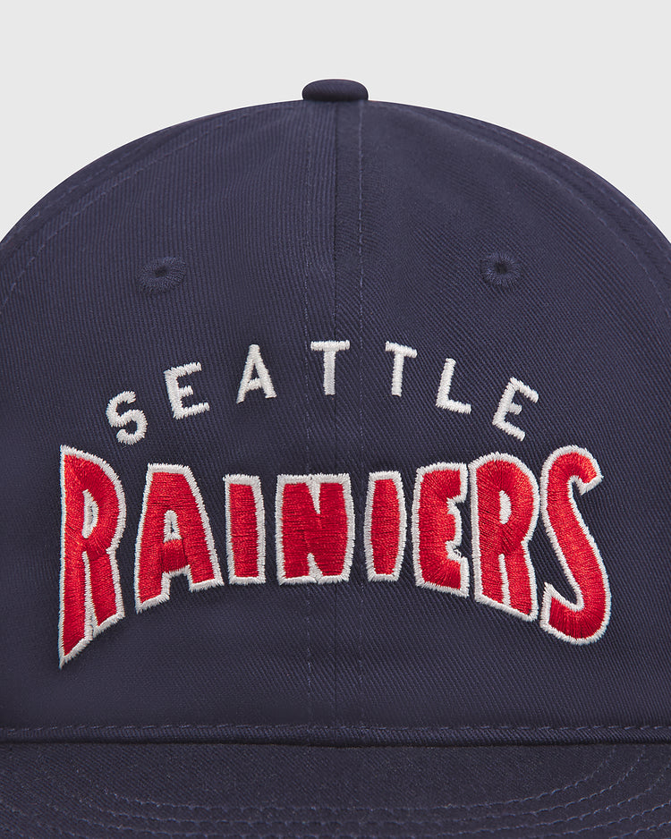 Close-up of the Seattle Rainiers 1941 Cotton Twill Ballcap by Ebbets Field, featuring SEATTLE RAINIERS embroidered in white and red on the front. Inspired by the legendary 1941 Pacific Coast League team, this classic navy blue cotton twill hat captures a piece of baseball history.