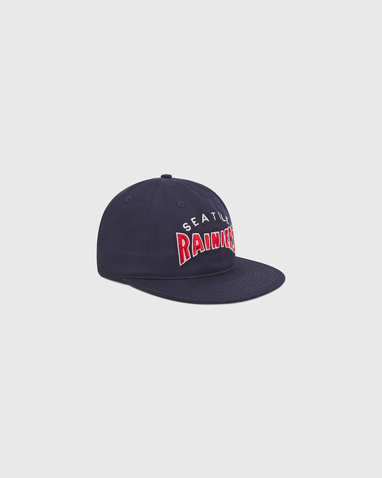 The Ebbets Field Seattle Rainiers 1941 Cotton Twill Ballcap features a navy blue cotton twill design with “SEATTLE” embroidered in white and “RAINERS” in bold red letters on the front, inspired by the classic ballcap worn during the 1941 Pacific Coast League season, shown here on a light gray background.