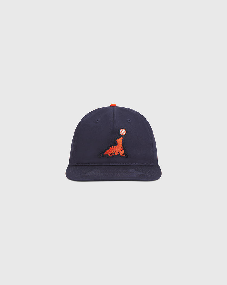 The Ebbets Field San Francisco Seals Cotton Twill Ballcap is a navy blue vintage-inspired baseball hat, featuring an embroidered orange seal balancing a red and white ball on its nose, presented against a plain light background.