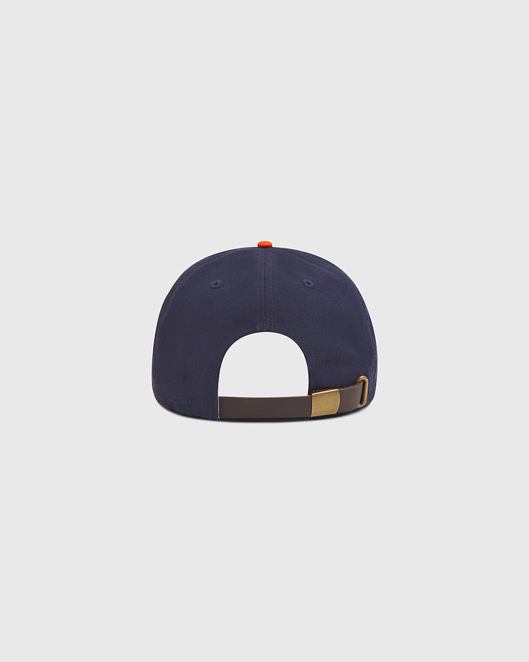 A San Francisco Seals Cotton Twill Ballcap by Ebbets Field is shown from the back, featuring a brown adjustable strap with a brass buckle and a small red button on top. The navy blue vintage baseball hat stands out against the light gray background.