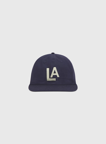 The Ebbets Field Los Angeles Angels (PCL) 1942 Cotton Twill Ballcap features a flat brim and bold white “LA” embroidery on the front, centered against a plain light gray background—an authentic recreation of the classic 1942 minor league baseball hat.