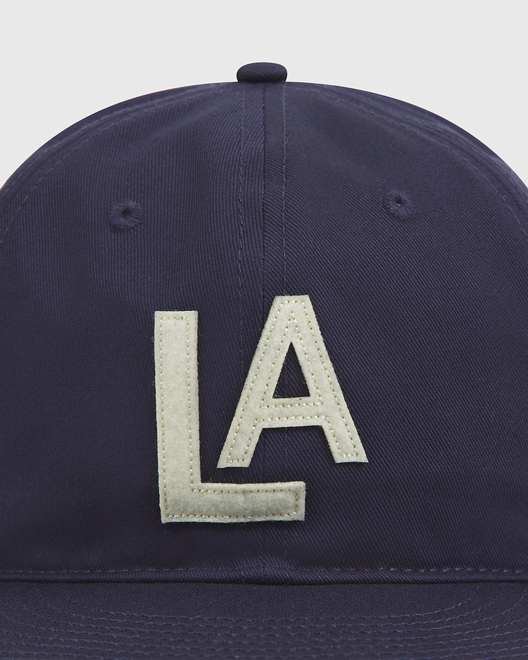 A close-up of the Ebbets Field Los Angeles Angels (PCL) 1942 Cotton Twill Ballcap in navy blue, featuring large white embroidered “LA” letters on the front, inspired by the classic 1942 Los Angeles Angels Pacific Coast League baseball hat.
