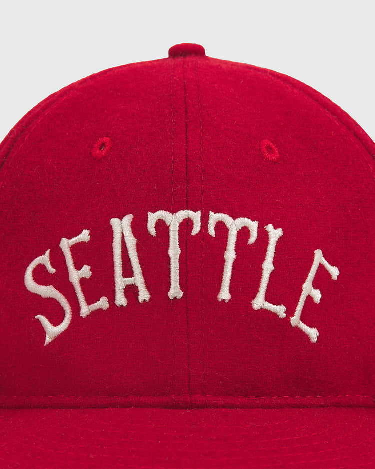 A close-up of the Ebbets Field Seattle City Series Wool Ballcap, featuring “SEATTLE” embroidered in arched white letters on the front and crafted from genuine wool broadcloth for a classic look.