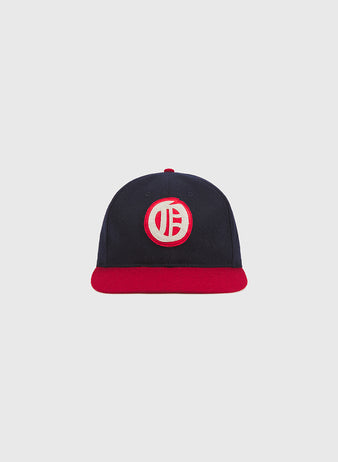 The Ebbets Field Oakland Oaks 1948 Authentic Wool Ballcap, featuring a navy blue wool body, a red brim, and a circular white-and-red embroidered logo on the front inspired by the original 1948 Oakland Oaks design, is shown against a plain light grey background.