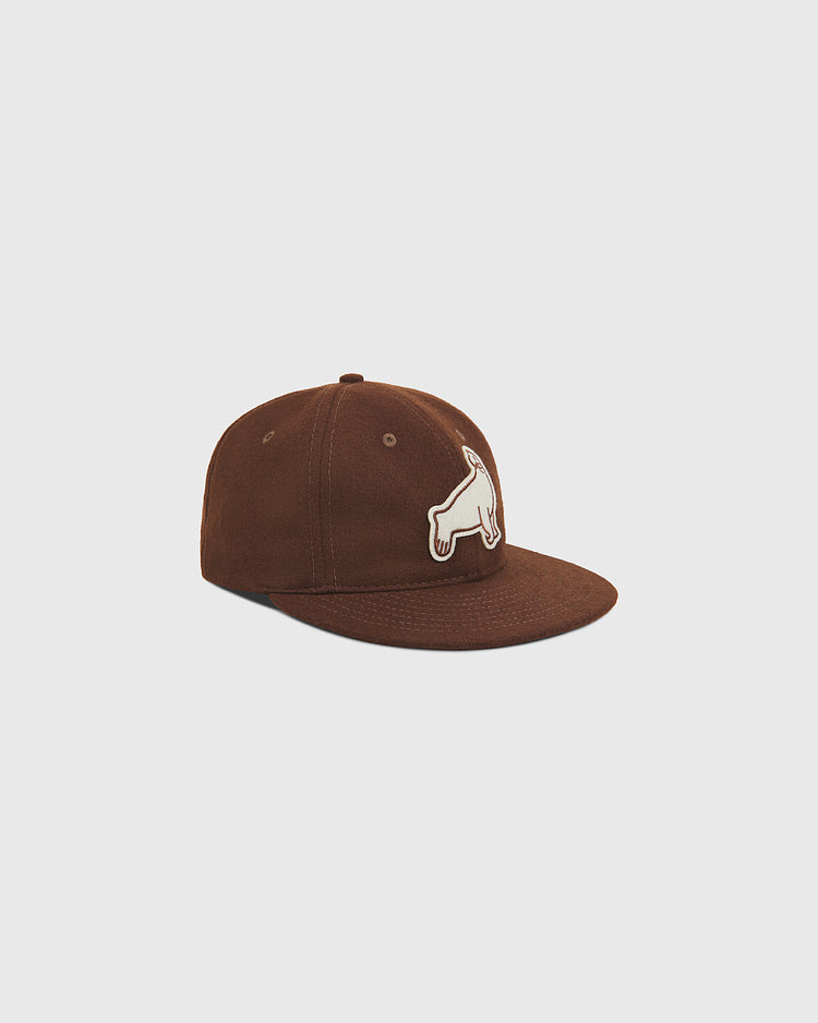 The Ebbets Field San Francisco Seals 1940 Wool Ballcap is a vintage-style brown cap with a flat brim, accented by a white dog patch on the front. Inspired by the classic 1940 San Francisco Seals design, this ballcap is displayed at an angle against a plain light gray background.