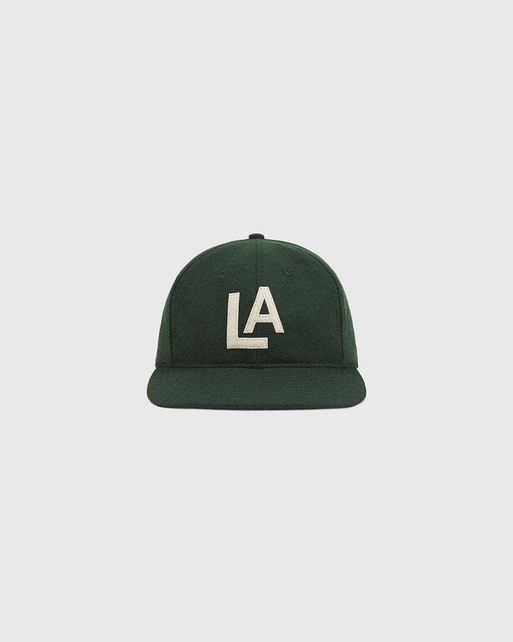 The Ebbets Field Los Angeles Angels (PCL) 1942 Authentic Wool Ballcap features a dark green wool construction with a flat brim and bold white “LA” lettering embroidered on the front, inspired by the 1942 Los Angeles Angels of the Pacific Coast League, and is shown against a plain light backdrop.