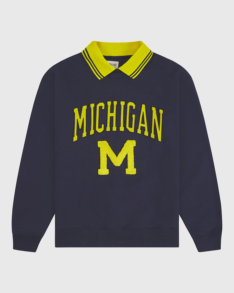 The Ebbets Field University of Michigan Collared Crewneck is a navy blue long-sleeve sweatshirt featuring a yellow-striped collar and a bold yellow MICHIGAN M on the front.