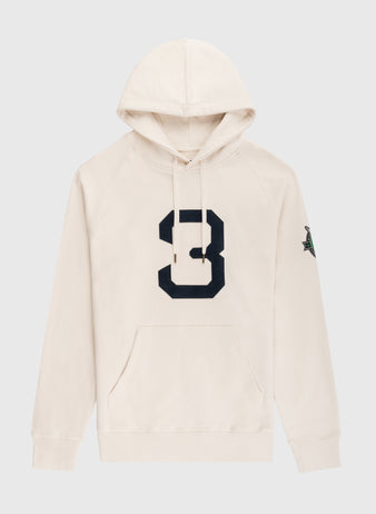 The EFF Babe Ruth Cotton French Terry Pullover Hoodie features cream heavyweight cotton, a bold black number 8 on the front, a green and black sleeve patch, front pocket, and drawstrings—a modern nod to the classic Babe Ruth hoodie.