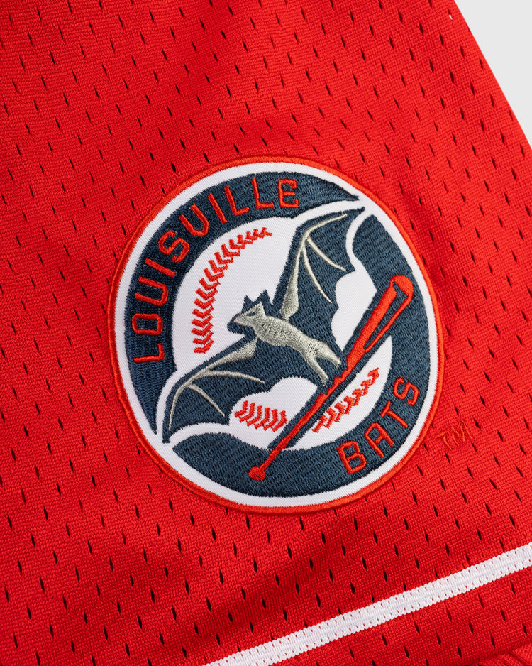 A close-up of the Ebbets Field ELLY DE LA CRUZ BUTTON UP MESH JERSEY in red, featuring a Louisville Bats logo patch with a bat flying over a baseball and “Louisville Bats” in a circular design.