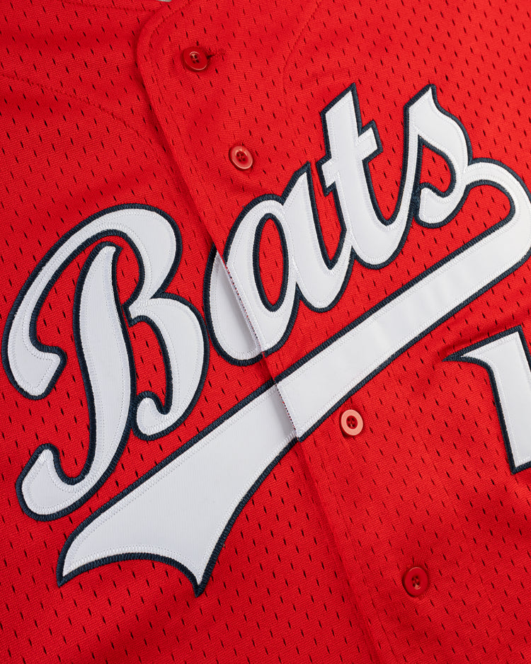 Close-up of the ELLY DE LA CRUZ BUTTON UP MESH JERSEY in red by Ebbets Field, featuring Bats in large, white, stylized lettering across the front.