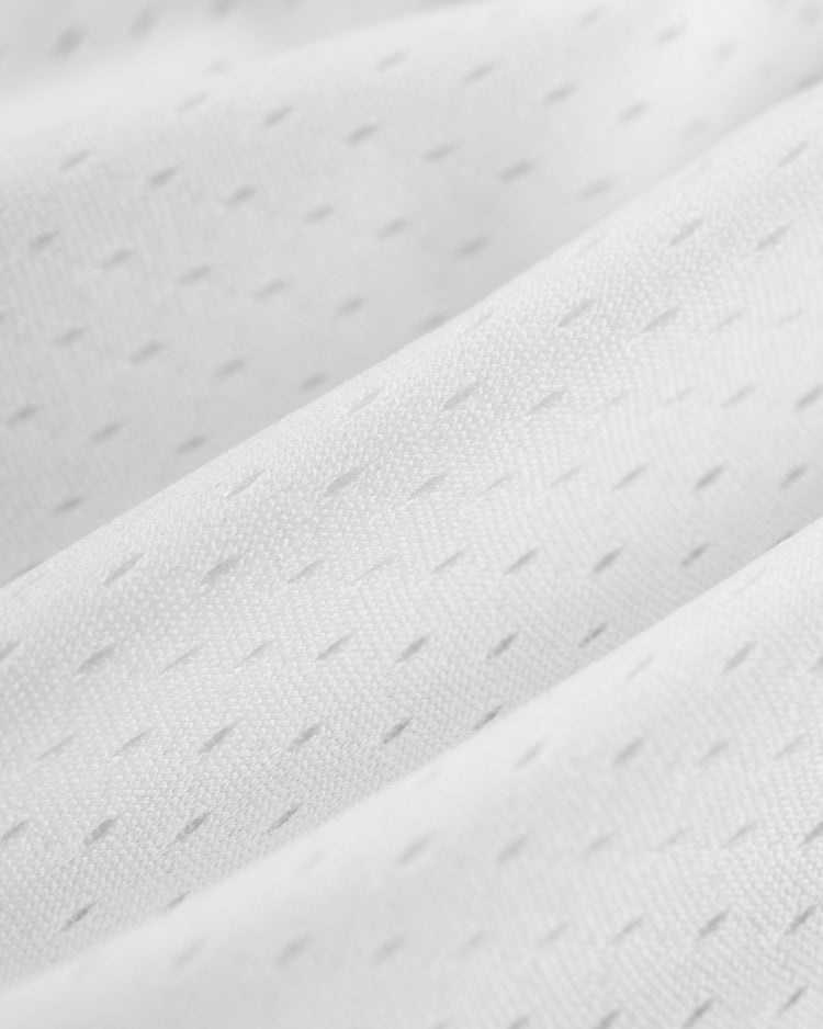 Close-up of the Ebbets Field JULIO RODRIGUEZ BUTTON UP MESH JERSEY in WHT/BLK, featuring white textured, breathable mesh fabric with small perforations and gentle folds.