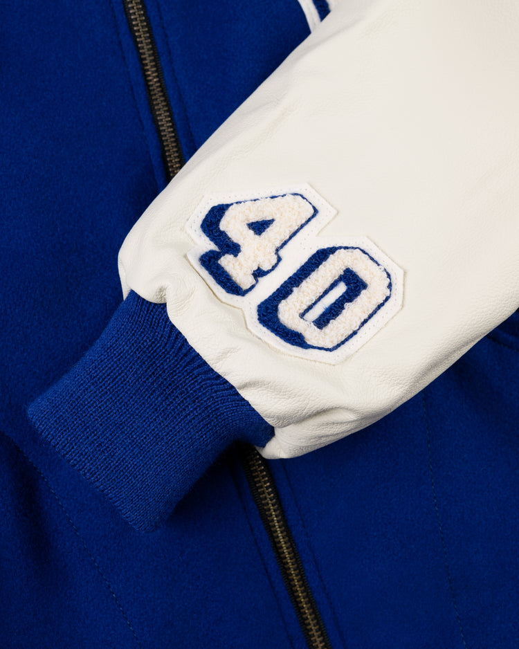 Close-up of the EFF Brooklyn Dodgers 1940 Authentic Wool & Leather Varsity Jacket sleeve with a blue ribbed cuff, a white patch featuring a blue-outlined number 40, and a visible black zipper—capturing the classic Ebbets Field style.