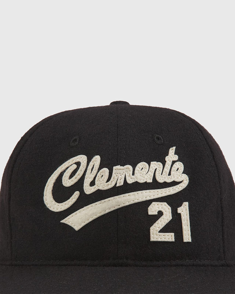 The Clemente Museum X Ebbets Field Wool Ballcap by Ebbets Field features a black wool design with “Clemente” in white script and the number 21 stitched below, inspired by the iconic Clemente Collection at the Roberto Clemente Museum.