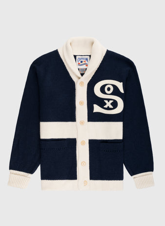 The EFF Chicago White Sox 1926 Wool Shawl Collar Sweater features navy blue wool, cream trim and buttons, two front pockets, a shawl collar, and a large cream Sox logo on the chest. Inspired by the 1926 team sweater.