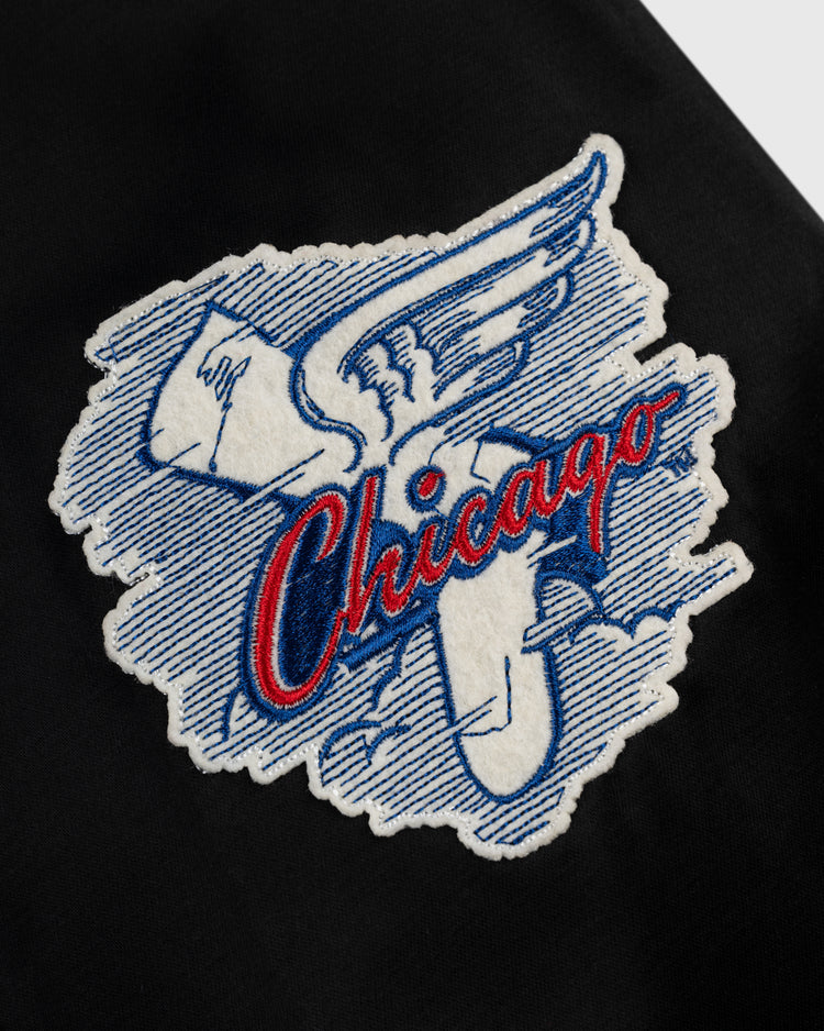 Embroidered patch with a blue and white winged pill and Chicago in red cursive on black fabric—ideal for customizing your EFF Chicago White Sox 1959 Satin Windbreaker Jacket.