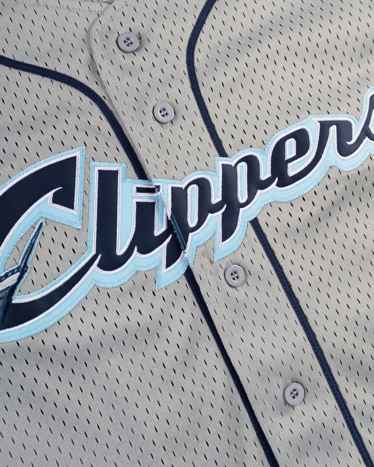 Close-up of the FRANCISCO LINDOR BUTTON UP MESH JERSEY GRY by Ebbets Field, a gray mesh baseball jersey with navy trim and buttons, featuring “Clippers” in large blue and white letters across the front.