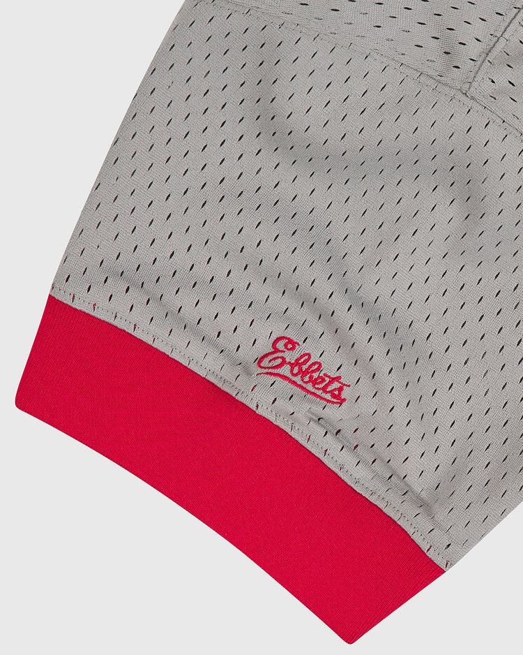 Close-up of the Ebbets Field Aloha 100th Infantry 1942 Mesh V-Neck Jersey’s gray perforated sleeve and bright red ribbed cuff, with “Ebbets” embroidered in red near the cuff, honoring the legacy of Japanese-American baseball.