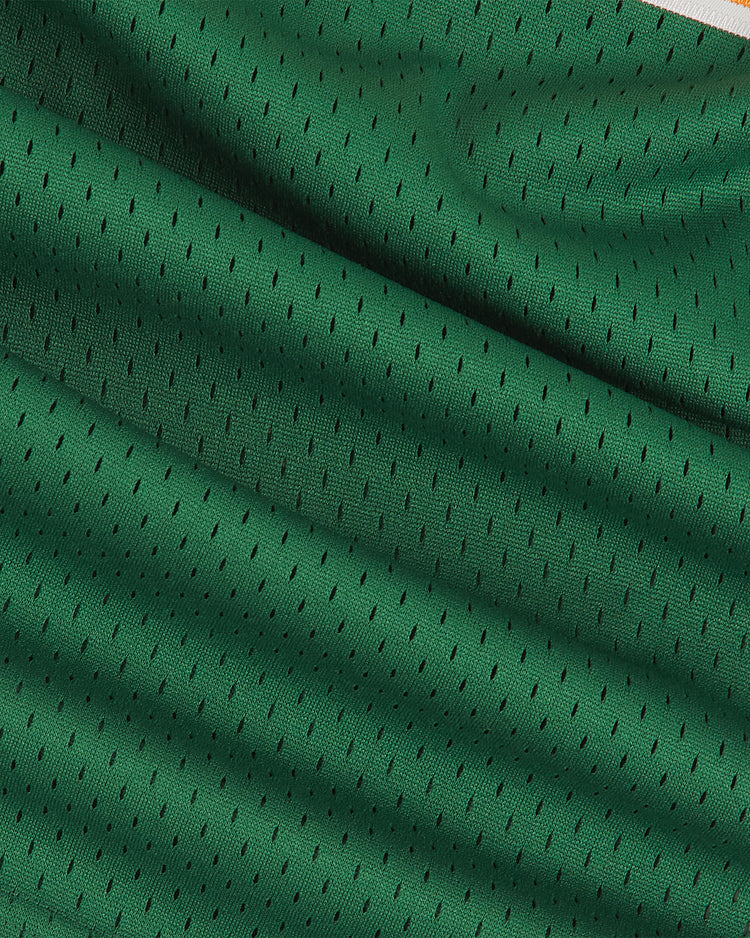 Close-up of green mesh fabric on the Ebbets Field University of Hawaii Rainbow Warriors Mesh V-Neck Jersey, featuring small black ventilation holes and a white edge stripe, highlighting its breathable texture and material folds.
