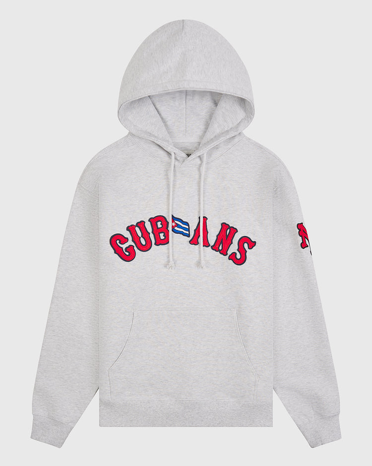 Introducing the New York Cubans Heavyweight Cotton Terry Pullover Flag Hoodie by Ebbets Field—a light gray, heavyweight cotton hoodie showcasing bold red “CUBANS” lettering and a small Cuban flag on the chest. Inspired by classic Negro League apparel, this hoodie also features a distinctive red patch on the left sleeve, drawstrings, and a convenient front pocket.