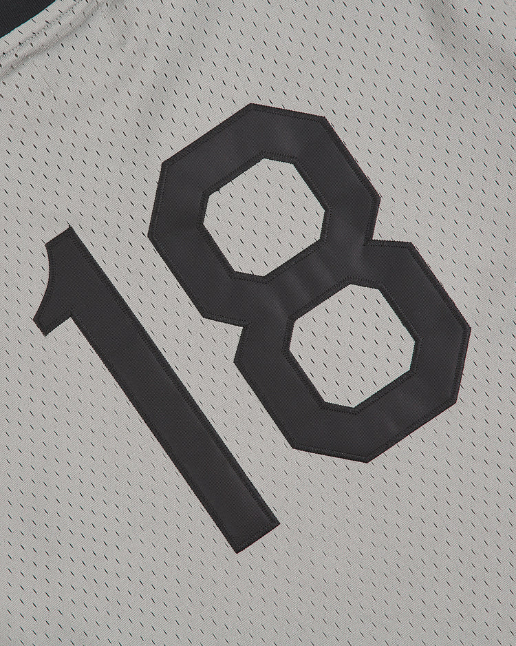 A close-up of the Ebbets Field Homestead Grays V-Neck Mesh Jersey, a white vintage baseball jersey featuring the black number 18 and breathable fabric with small ventilation holes.